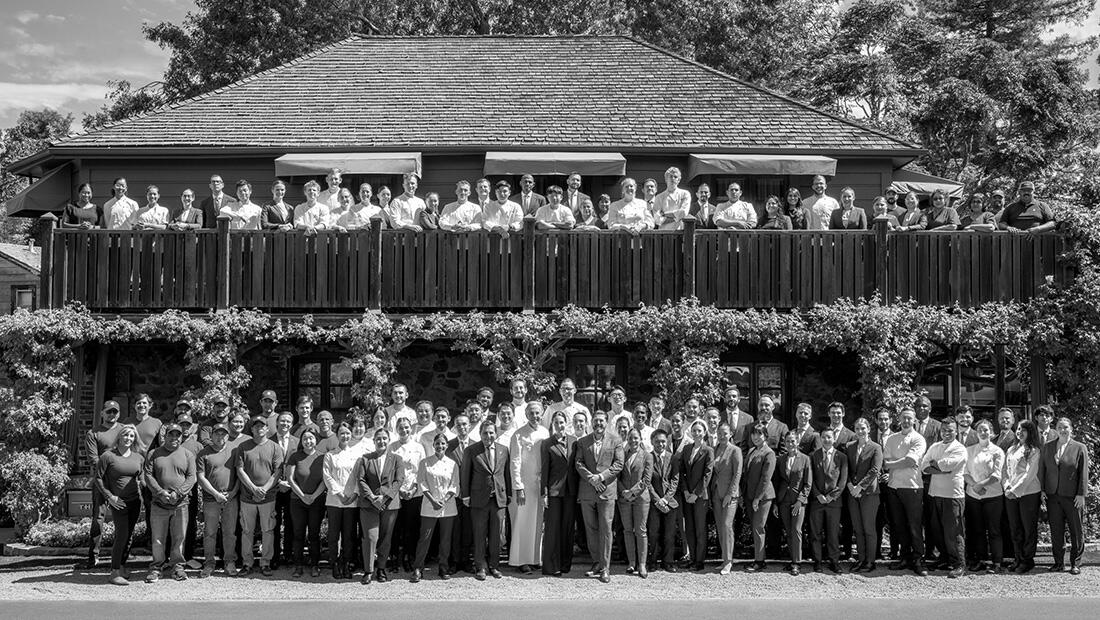 A large group of employees standing in front of an old building